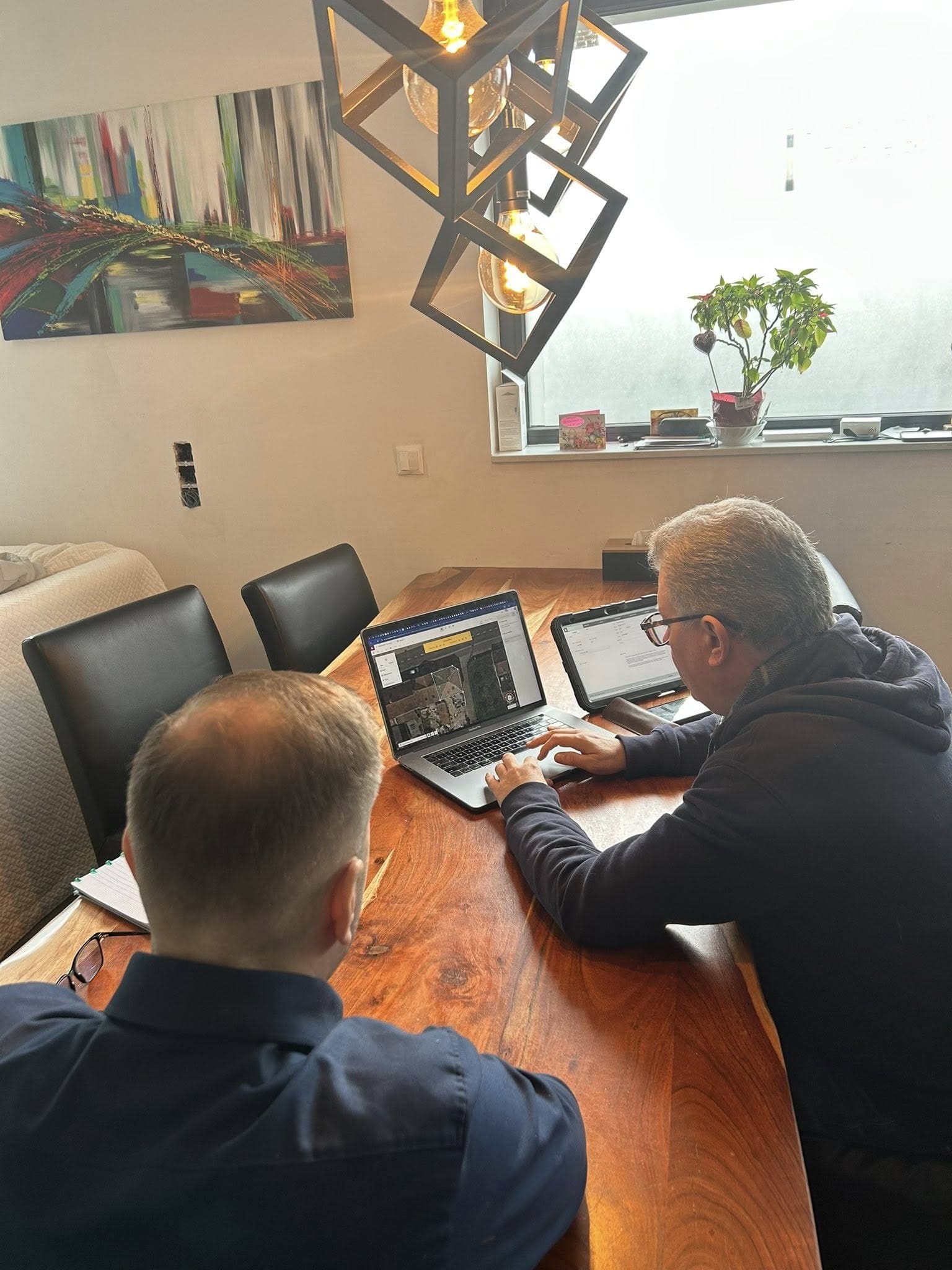 Adviesgesprek aan een houten tafel met laptop